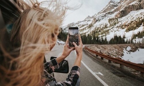 блондинка без лица зимой в машине снимает видео на телефон