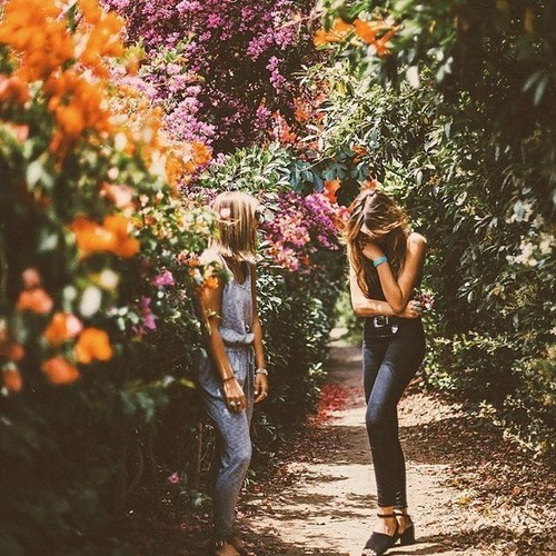 две девушки смеются в цветущем саду