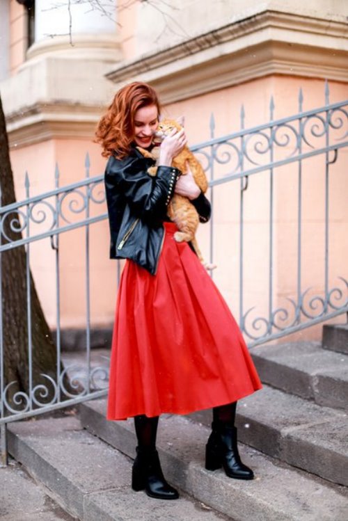 рыжая девушка в красной юбке на улице с рыжим котом на руках