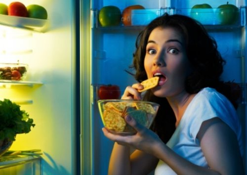 девушка ночью ест из открытого холодильника