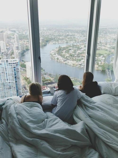 три девушки лежат у окна наблюдая за красотой города