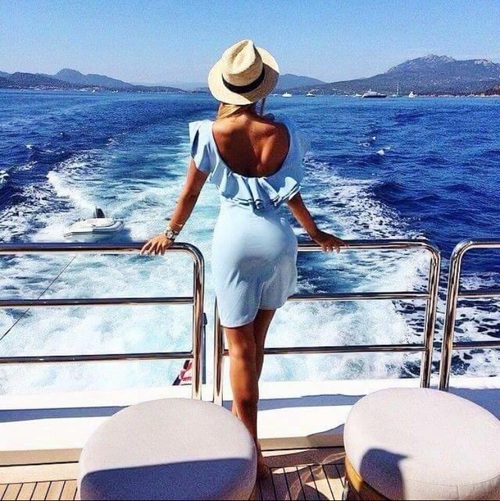 девушка в голубом платье со спины в шляпе летом на корабле