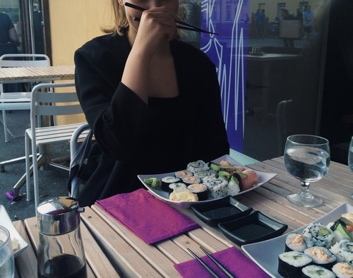 девушка в кафе кушает суши