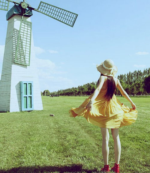 девушка в желтом платье спиной возле мельницы
