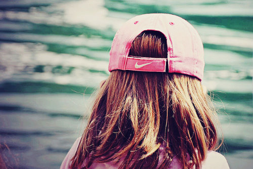рыжая девушка спиной в розовой кепке