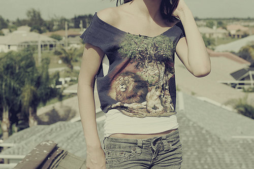 девушка без лица в черной футболке с львами