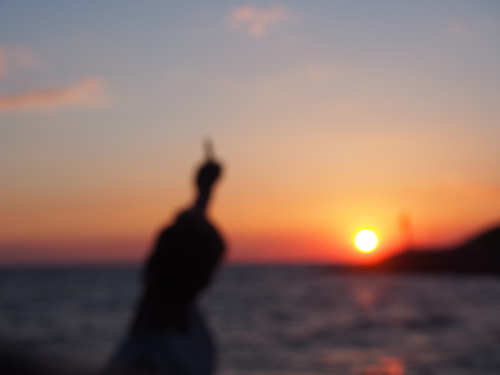 размытое нечеткое фото девушки на берегу моря на закате