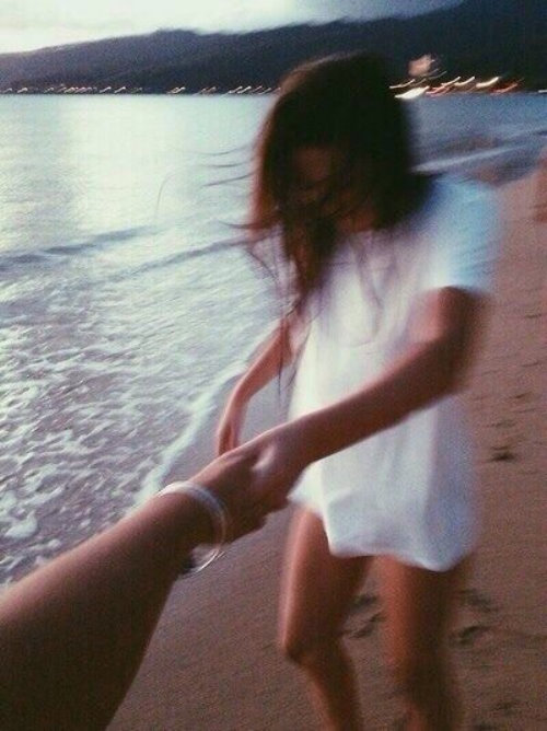нечеткое фото девушки с парнем за руку на берегу моря без лица