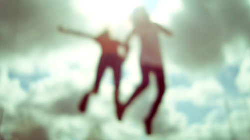  дві дівчини в стрибку на фоні неба нерізке фото