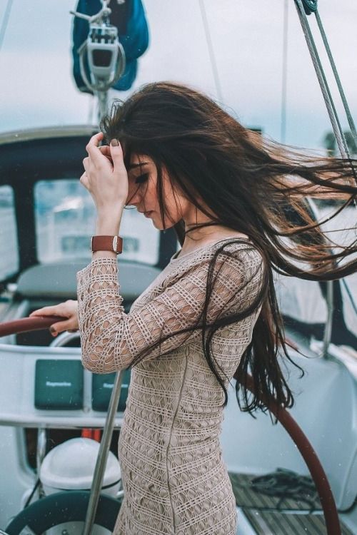 девушка на яхте с развевающимися волосами на море