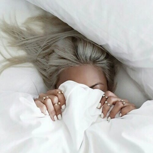 блондинка прячет лицо под одеяло
