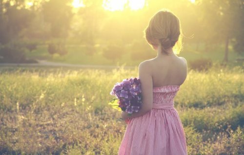романтичное фото девушки в платье спиной с букетом цветов
