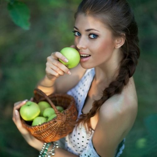 девушка с косой вид сверху ест яблоко