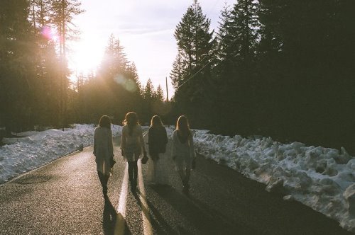четыре подружки идут вдоль трассы в солнечный зимний день