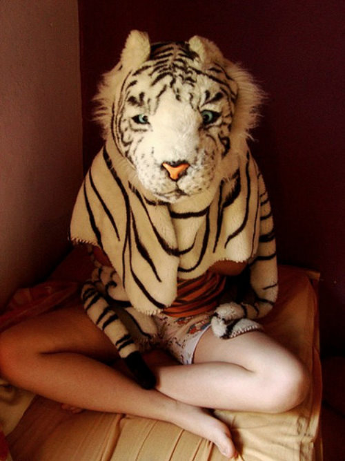 девушка в костюме белого тигра сидит на кровати
