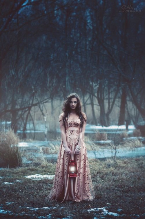 девушка в красивом платье в осеннем лесу с первым снегом с фонарем-подсвечником в руках