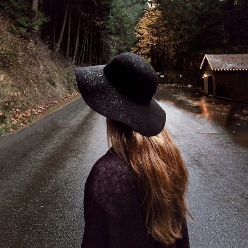 светловолосая девушка в черной шляпе под дождем