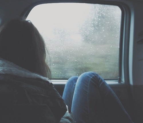 девушка греется на заднем сиденье авто за окном дождь