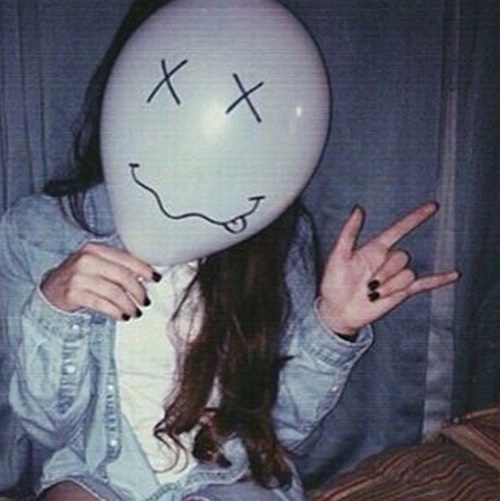 девушка прячет лицо за воздушным шариком
