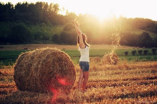 девушка осенью в поле среди сена