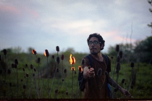 парень в очках поджигает растения