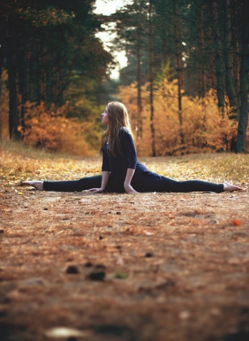 девушка села на шпагат в парке осенью