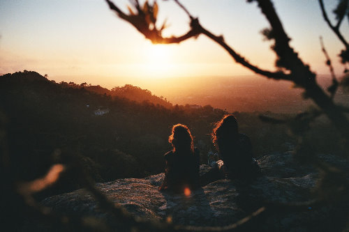 двое на вершине горы смотрят закат осеннего солнца
