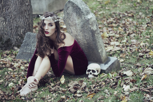 девушка в бордовом велюровом платье у надгробия с черепом идеи для осенней фотосессии