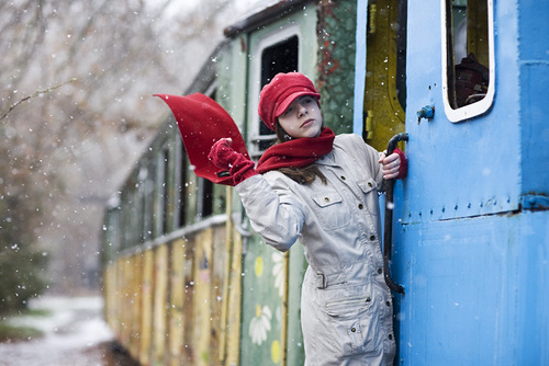 девушка повисла на поезде, развевается красный шарф, идет снег
