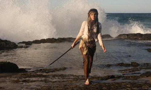 девушка со шпагой на фоне высокой волны океана