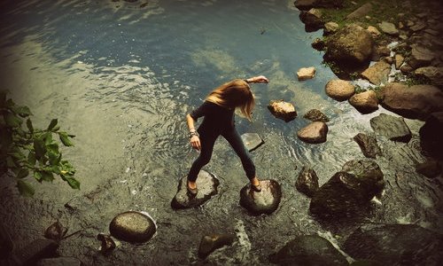 девушка с светлыми волосами переходит реку по камням вид сверху идеи для фотосессии
