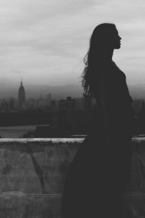 девушка в профиль ночью в темноте на фоне города
