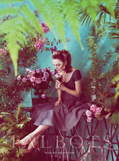 женщина нюхает цветы сидя на лавочке в оранжерее