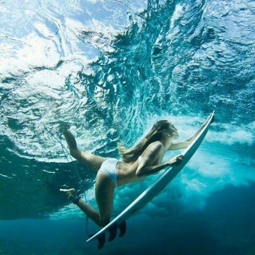 девушка серфингист в белом купальнике под водой