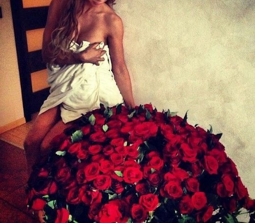 девушка в белом полотенце рядом с большим букетом роз на полу