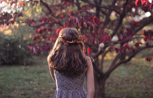 фото девушки со спины в венке из осенних листьев в черном платье в цветок