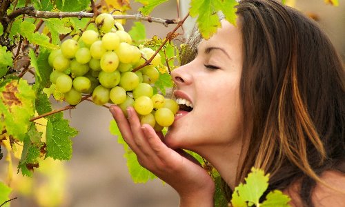 девушка с гроздью зеленого винограда