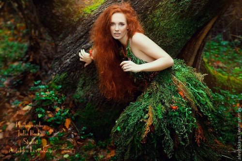 девушка в образе лесной нимфы у дерева в лесу в зеленых и рыжих тонах