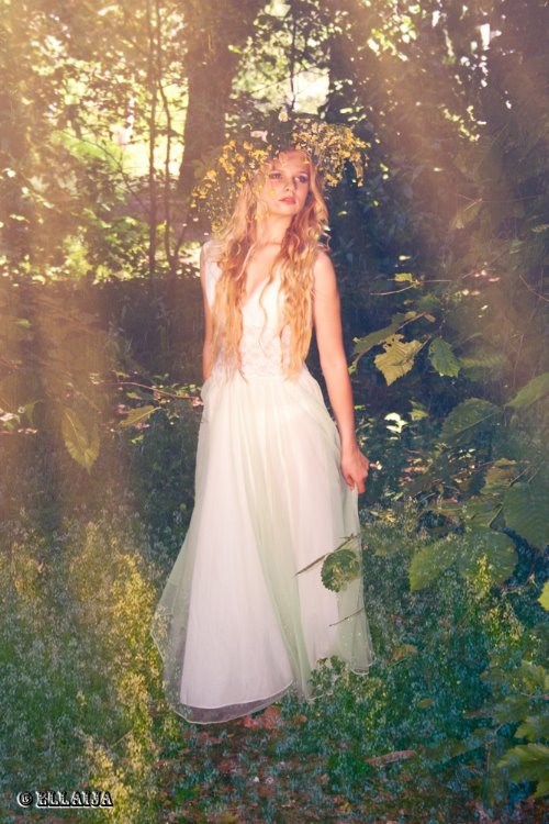 блондинка в длинном белом платье в венке в лесу