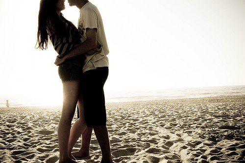 влюбленные без лиц обнимаются на песке