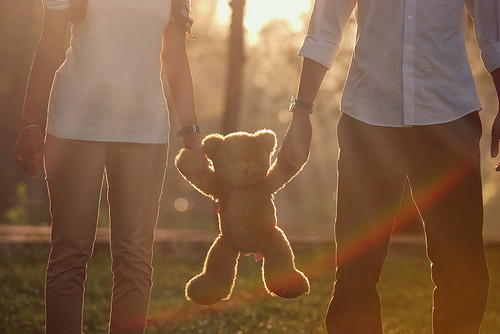 девушка и парень держат плюшевого медведя