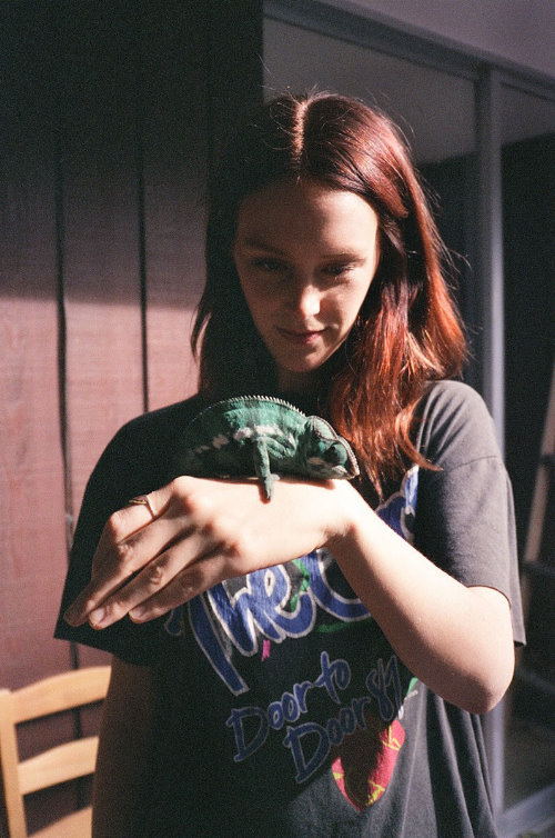 девушка с рыжеватыми волосами держит на руке хамелеона