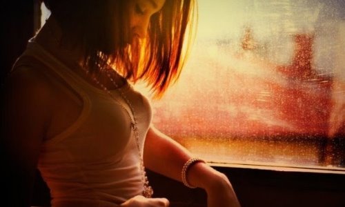 девушка с каре в белой майке у окна в солнечных лучах