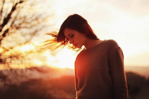 девушка в свитере на фоне заходящего солнца