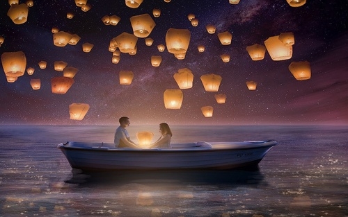 влюбленные в лодке пускают небесные фонарики