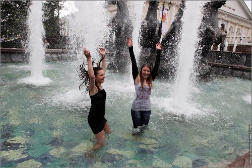 две девушки прыгают в фонтане