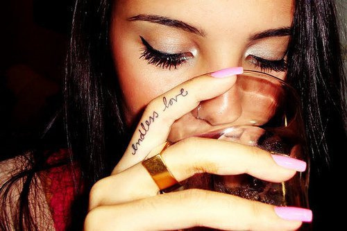 девушка пьет напиток из бокала с надписью на пальце endless love