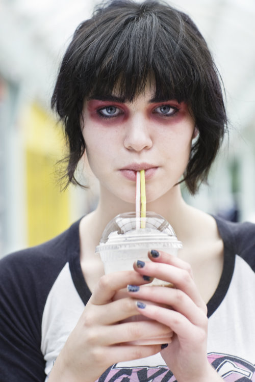 девушка со странным макияжем пьет молочный коктейль через соломинку