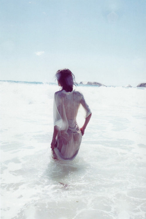 девушка в море в мокром прозрачном платье со спины
