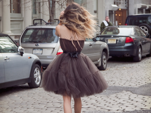 девушка идет вдоль дороги в пышном коротком платье со спины припаркованные автомобили